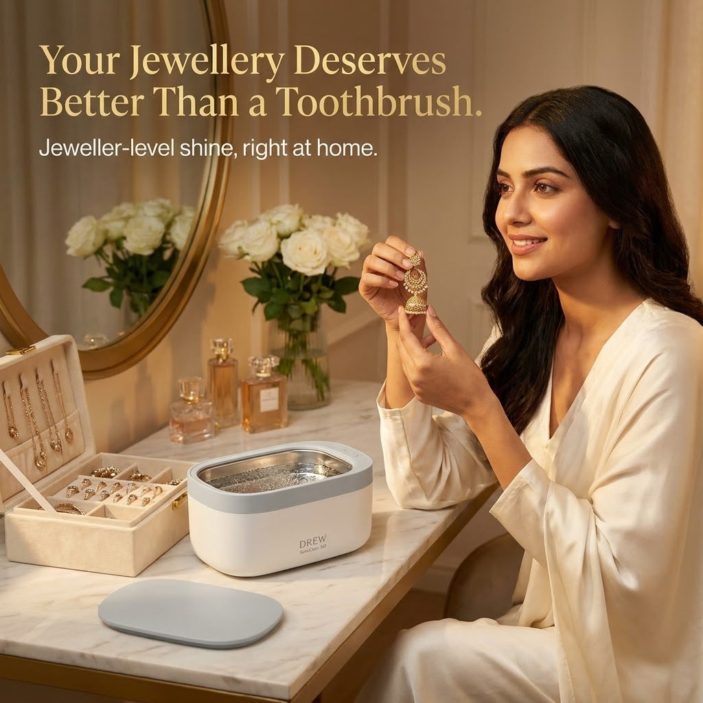 Woman holding freshly cleaned jhumka earrings beside the SonicClean 360 on a dressing table
